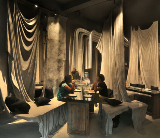 O restaurante Tease Me Café usa tecido velho revestido de concreto para criar um interior escultórico